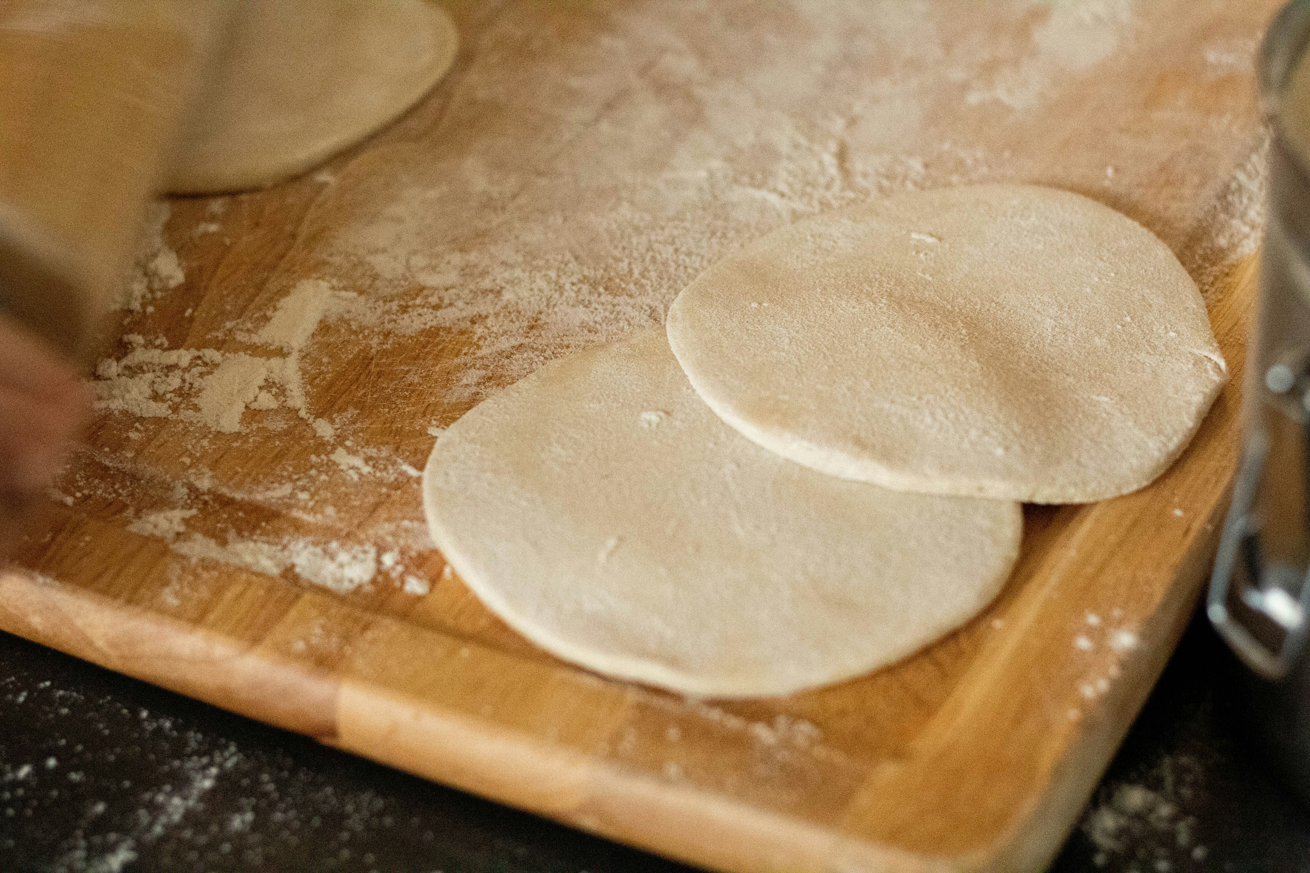 white dough on brown wooden chopping board